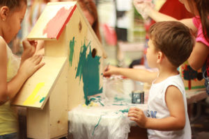 Kinder bauen und bemalen ein Vogelhaus